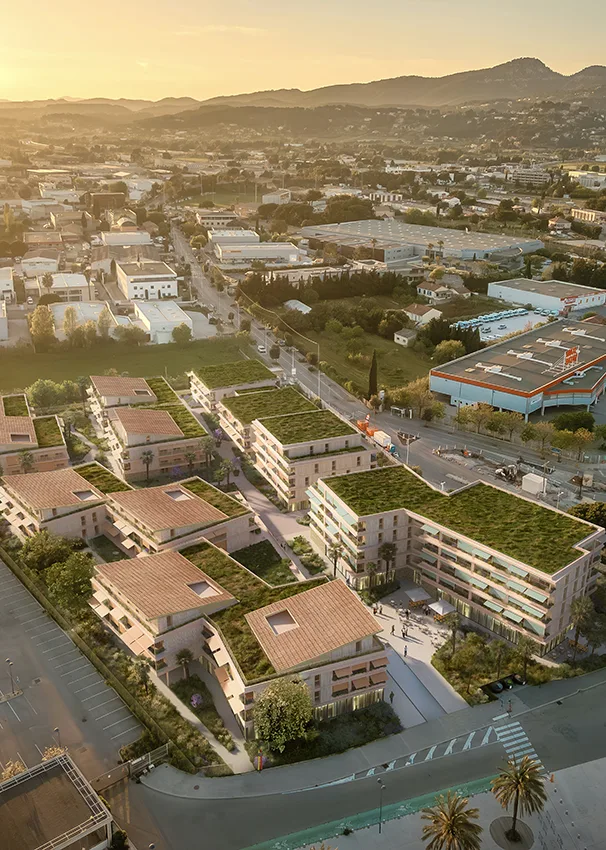 Vue aérienne de la résidence au coucher du soleil, toitures végétalisées et collines en arrière-plan